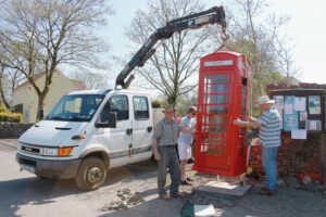 A phone box being lifted into place.