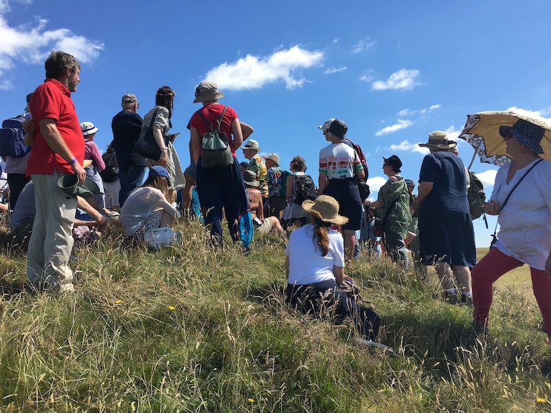 A group pf people standing and sitting on a hillside.