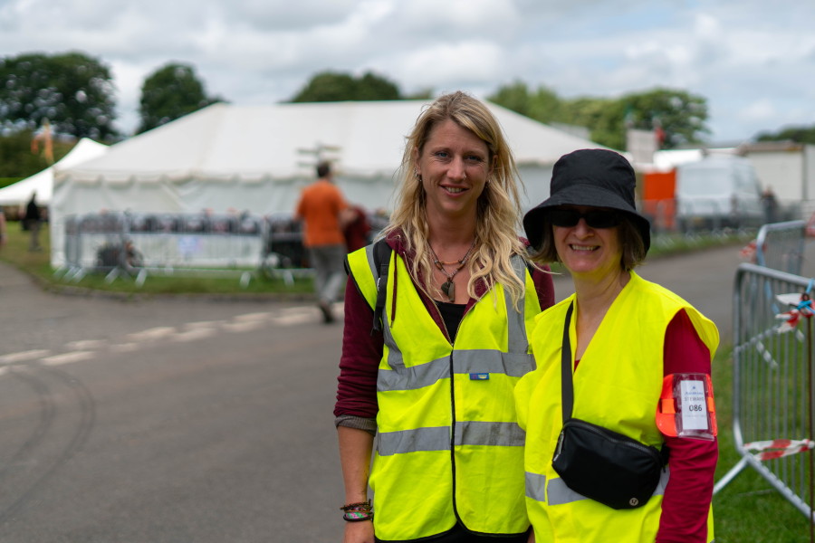 Two people wearing bright yellow vests smiling.