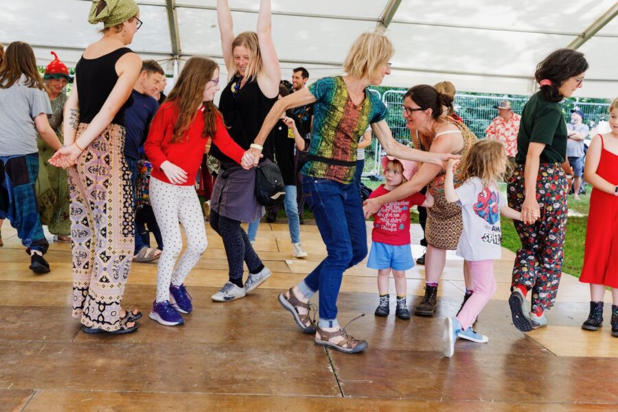 Adults and children dancing in a circle.